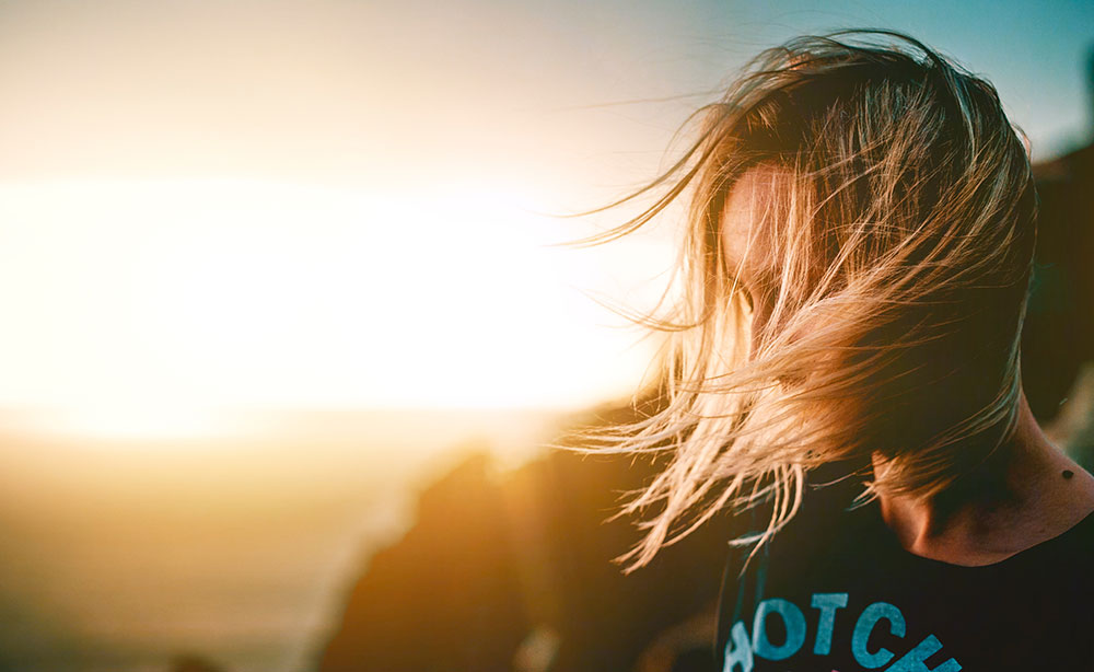 woman on cliff during sunset