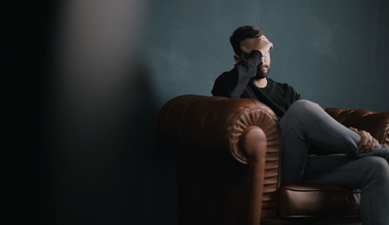 Man sitting on sofa in the dark