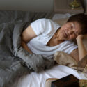 Senior woman lying in bed awake